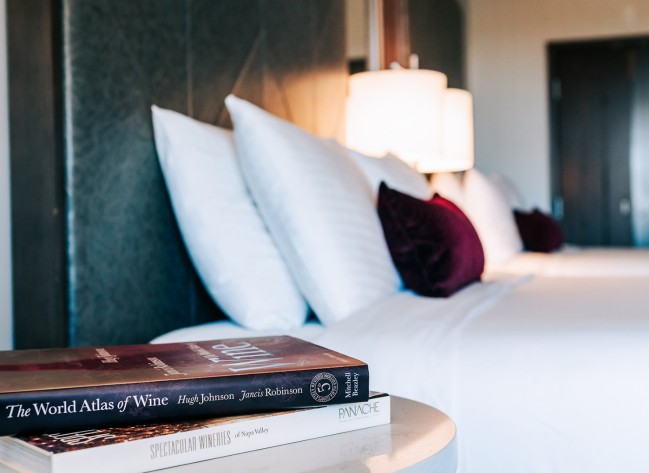 a stack of books on a table next to pillows