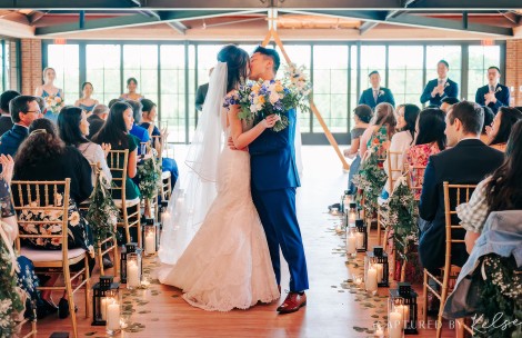 a man and woman kissing in a room with people and candles