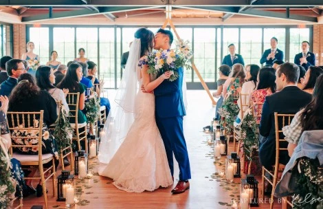 a man and woman kissing in a room with people and candles