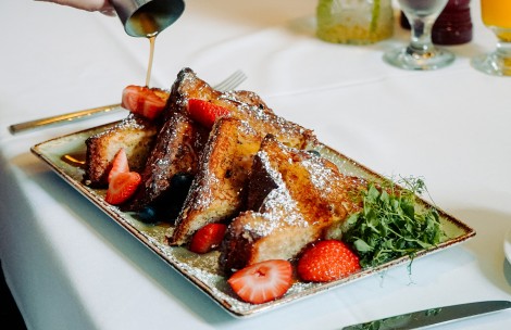 a plate of french toast with strawberries and sprinkles