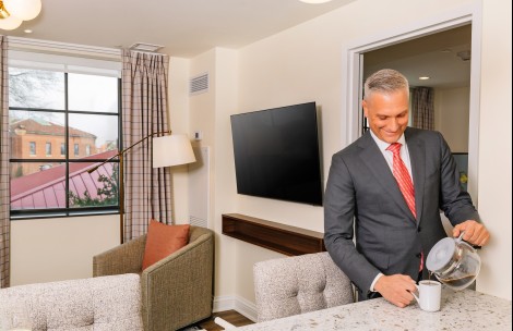 a man in a suit holding a cup