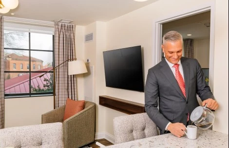 a man in a suit holding a cup