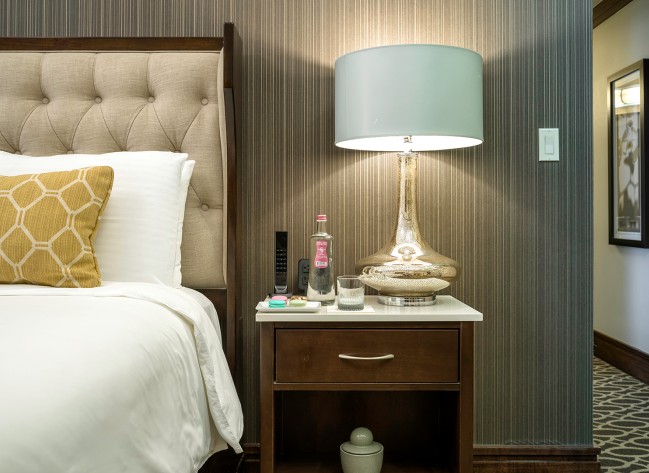 a lamp on a table next to a bed