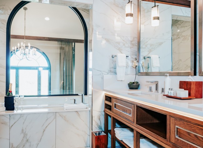 a bathroom with marble walls and a large mirror