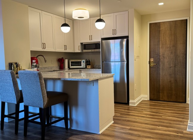 a kitchen with a bar and a refrigerator