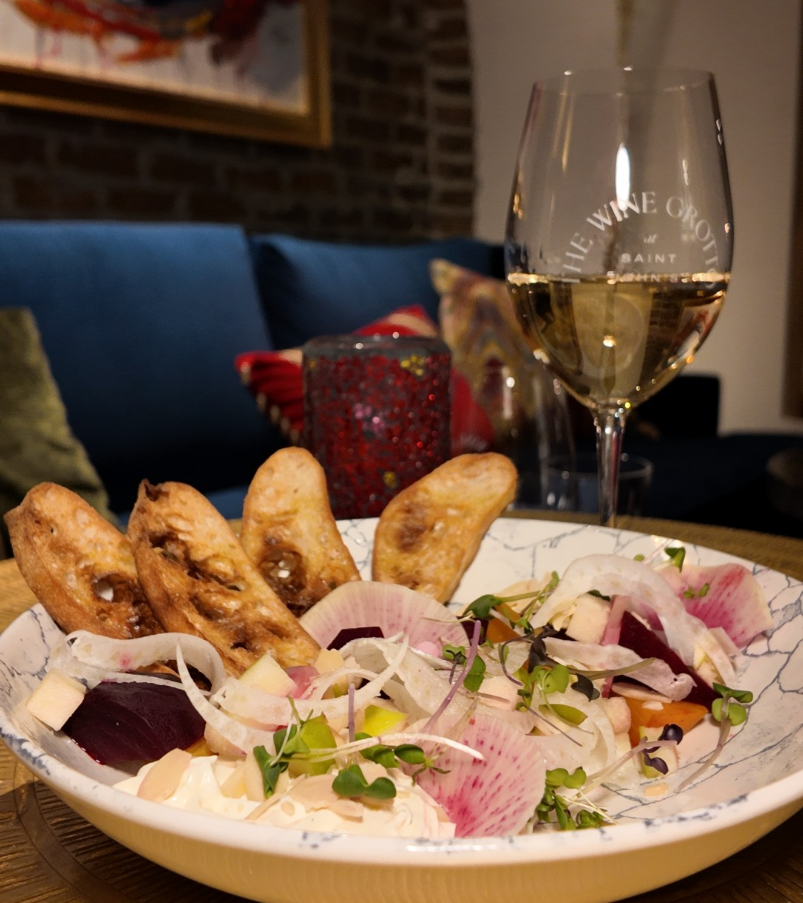 a bowl of food and a glass of wine