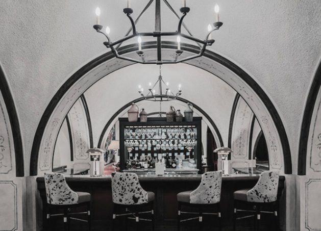 a bar with chairs and a chandelier