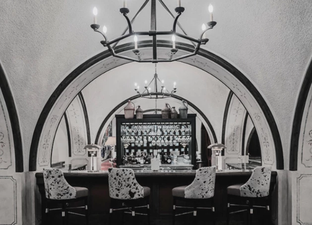 a bar with chairs and a chandelier