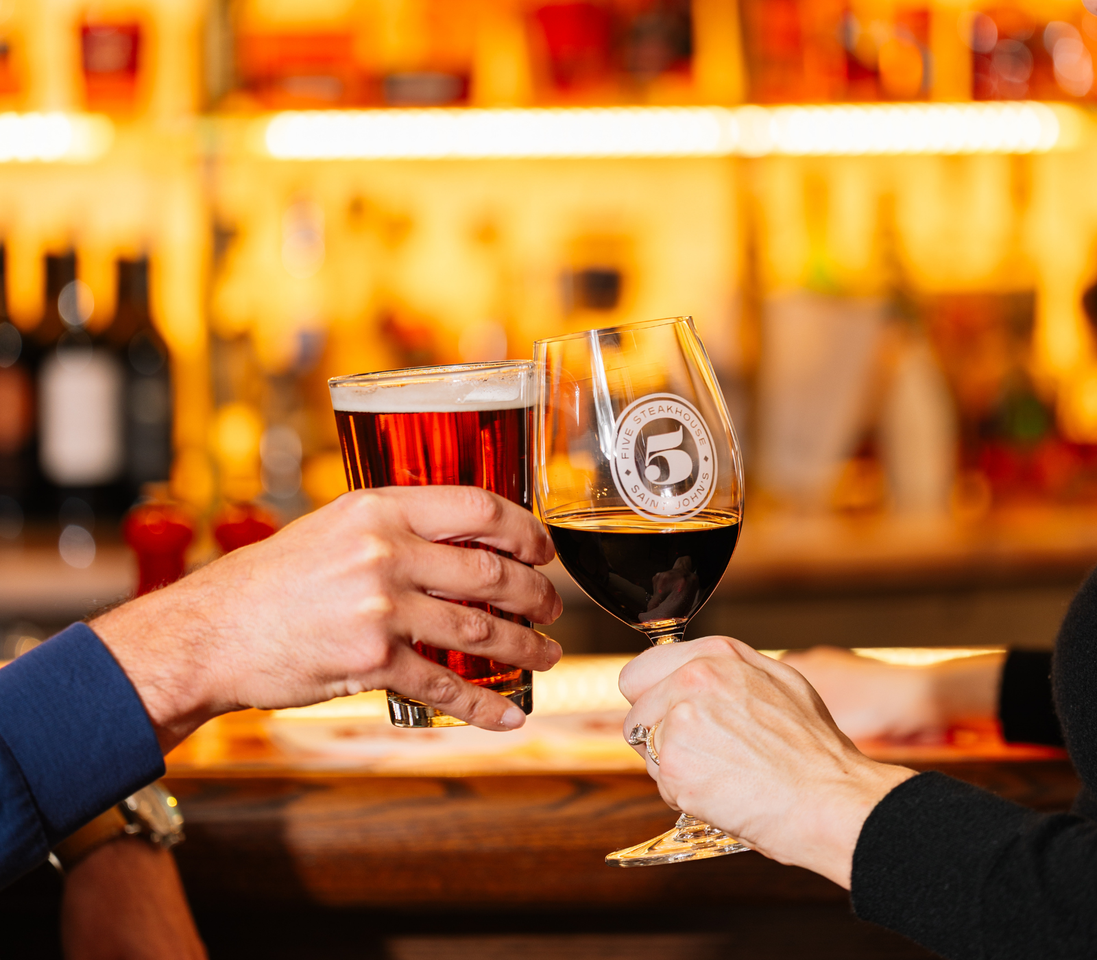 a couple of hands holding wine glasses