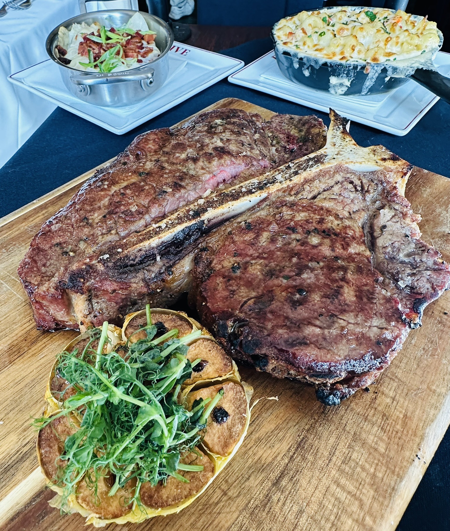 a steak and potatoes on a wooden board