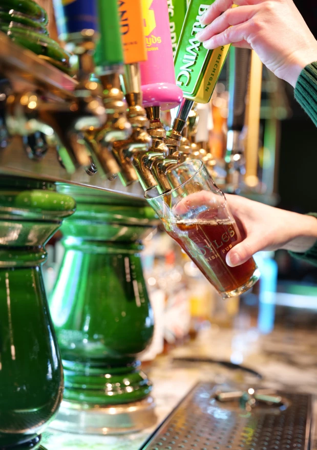 a hand holding a glass of beer