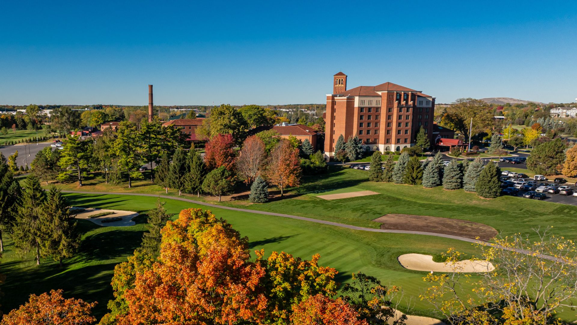 a large building with trees and a golf course