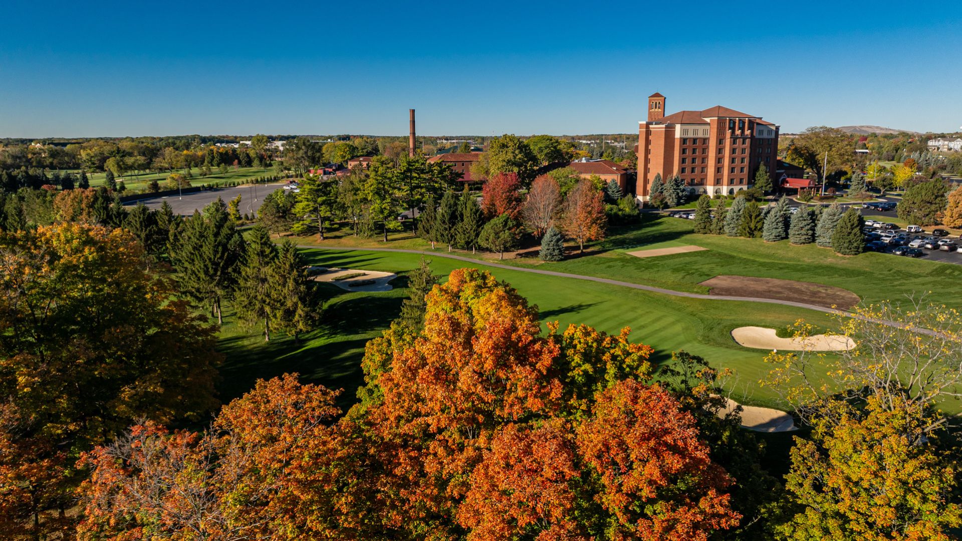 a large building with trees and a golf course