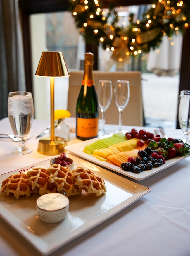 a table with plates of fruit and a bottle of champagne