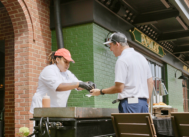 a man wearing gloves and gloves to a man who is holding a paper