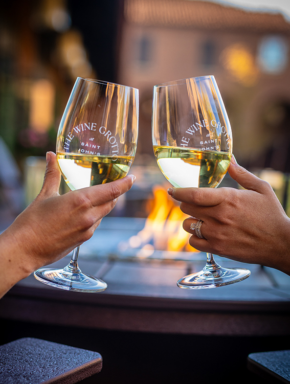 a pair of hands holding wine glasses