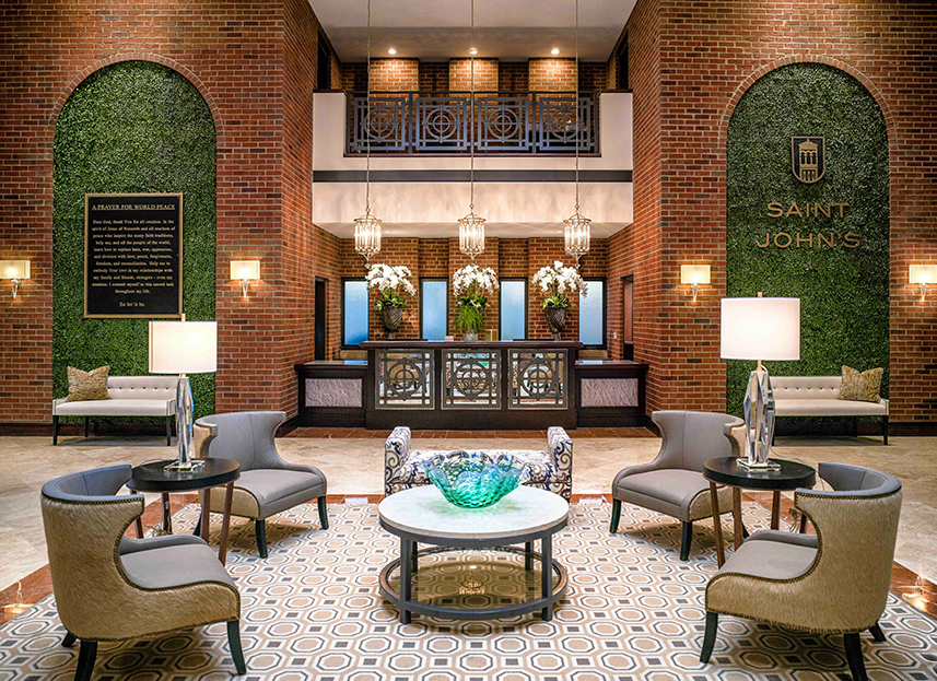 a lobby with a brick wall and chairs and a table