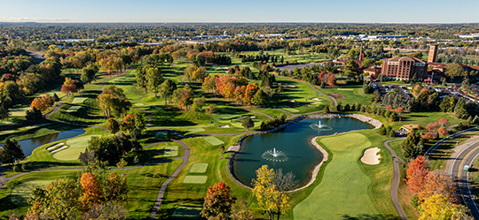 a golf course with water fountains and trees