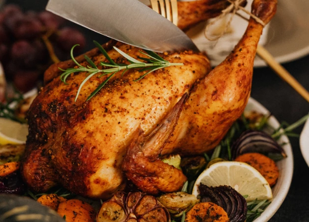 a chicken with a knife and vegetables