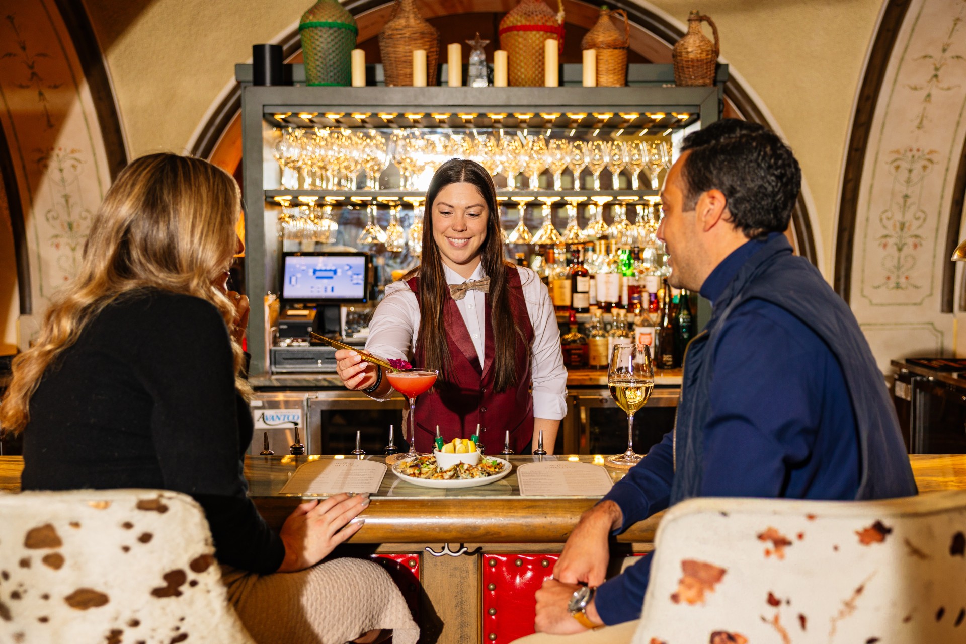a woman serving a drink to a couple of people