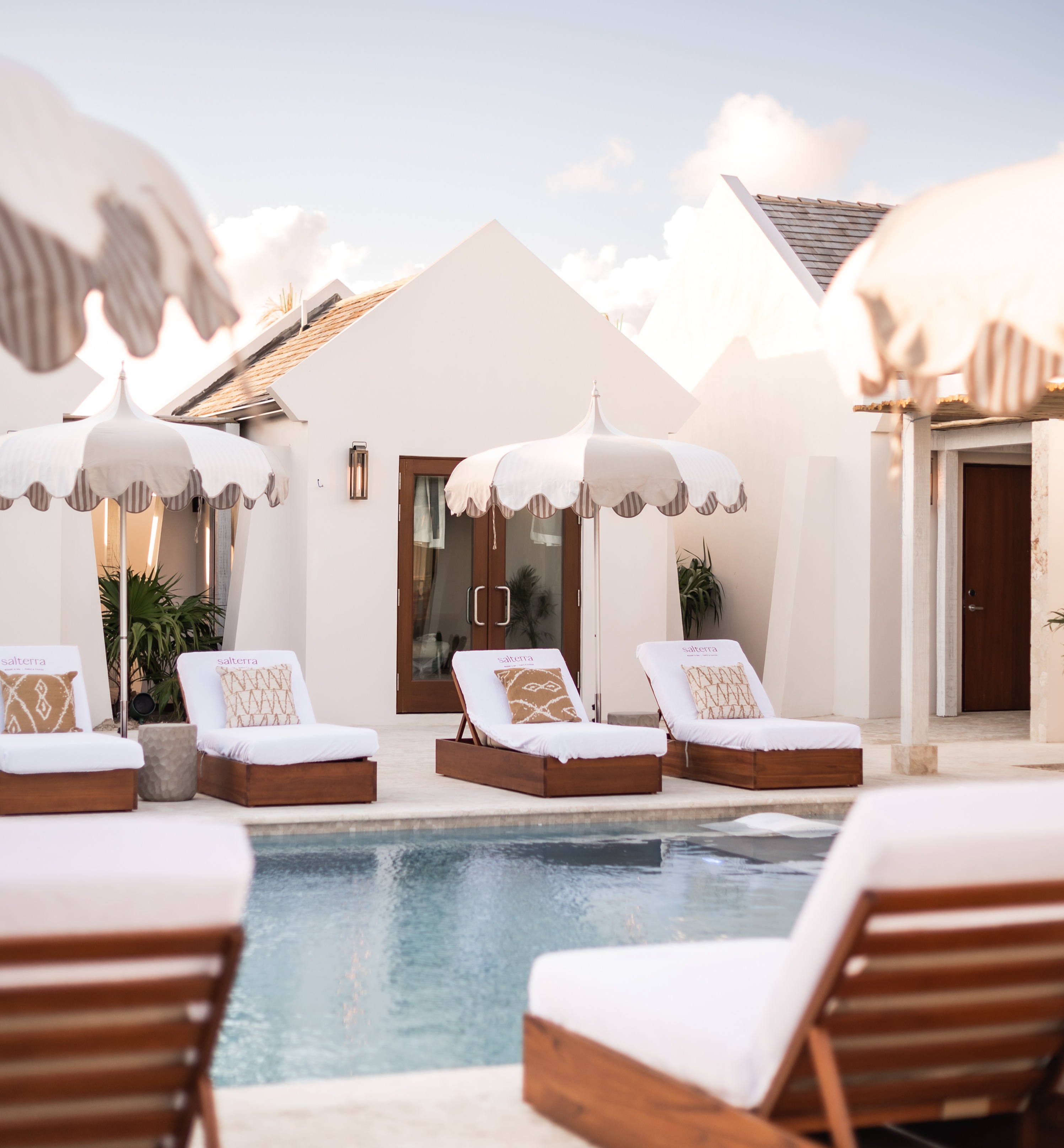 a pool with lounge chairs and umbrellas