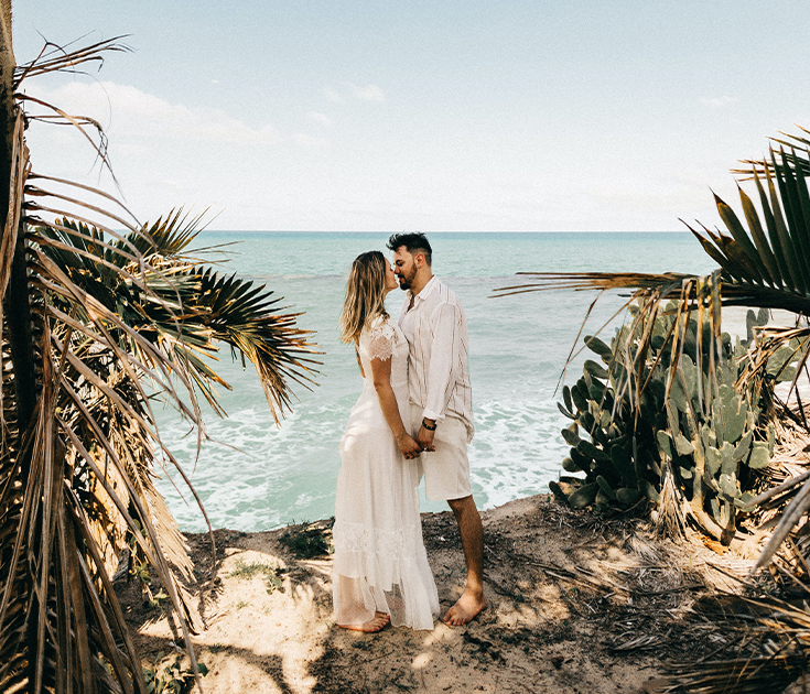 a man and woman kissing on a beach
