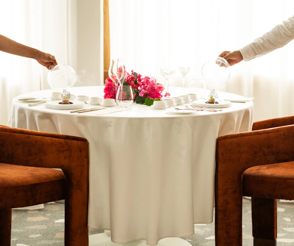 a couple of people pouring wine glasses into a table