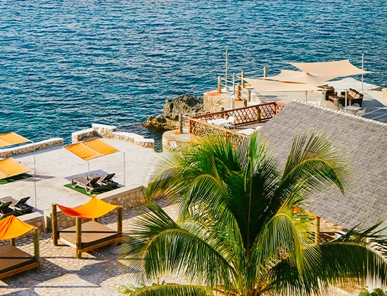 aerial view of exterior patio with orange cabanas with view of ocean