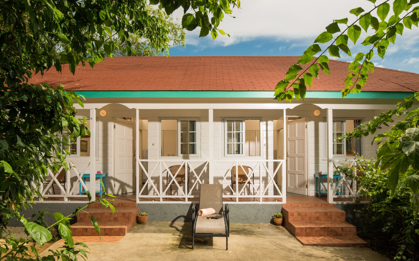 a white house with a deck chair and a bench