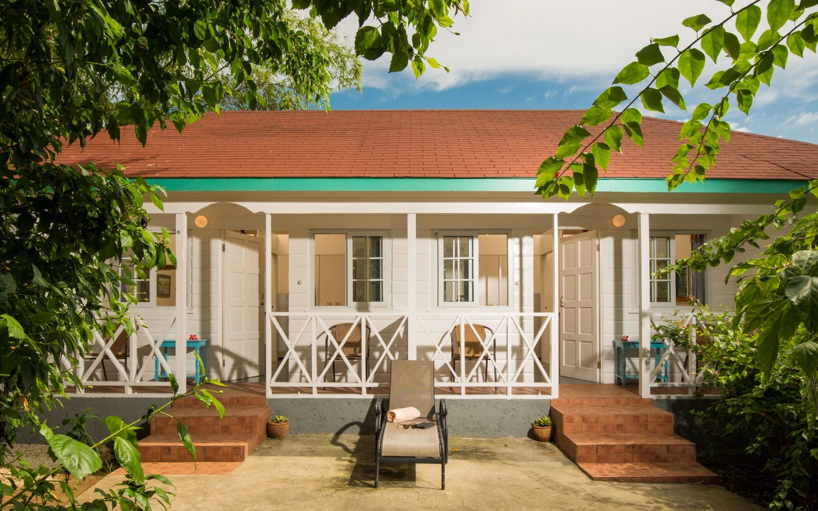 a white house with a deck chair and a bench