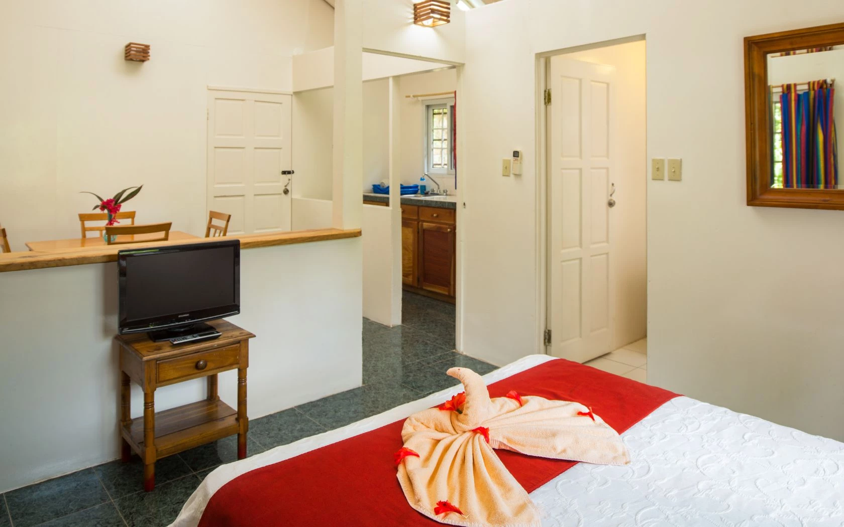 a room with a television and a towel on a bed