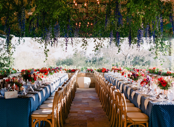 a long wooden walkway with tables and chairs and flowers on the side