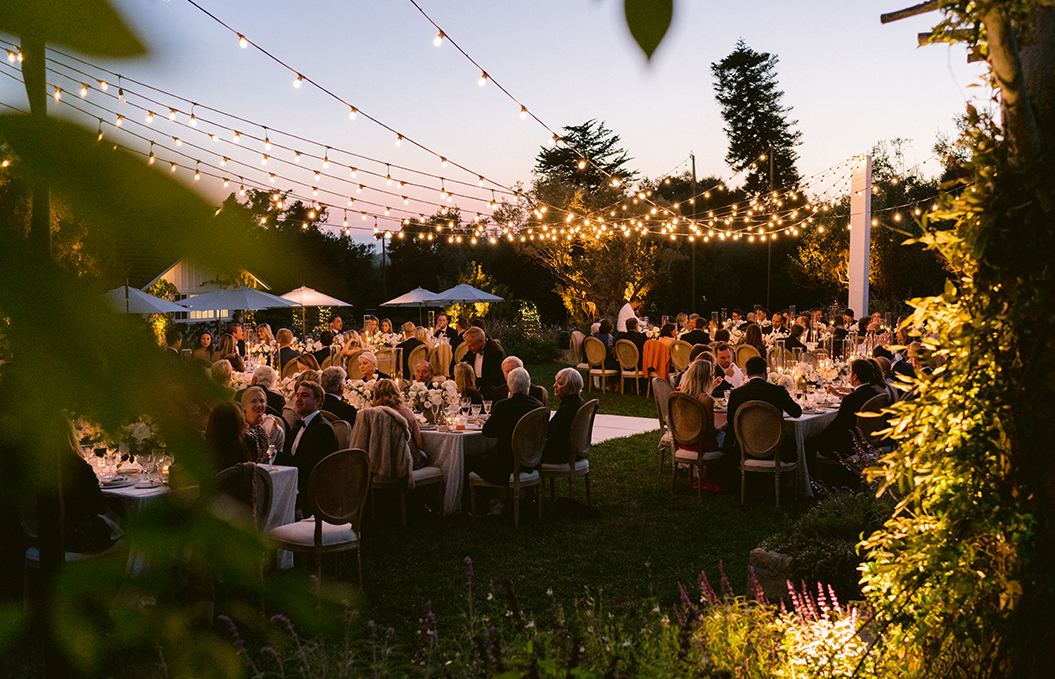 a group of people sitting at a table under a tent