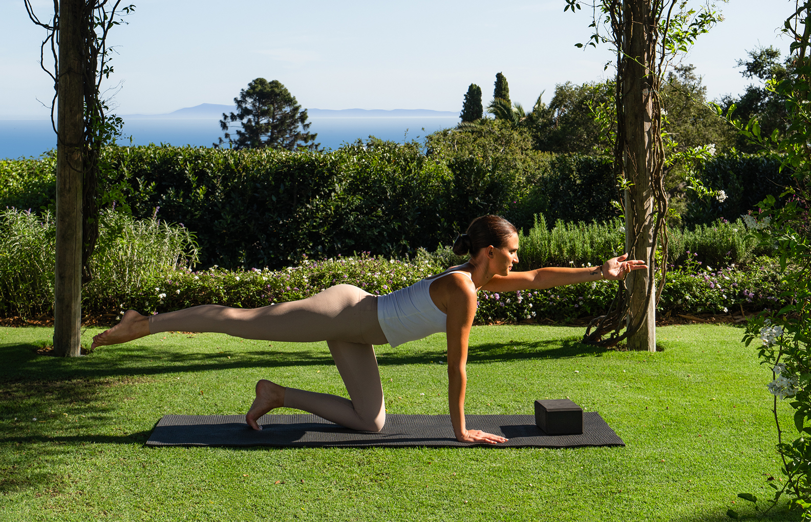a woman doing yoga on a mat in a yard