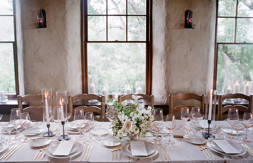 a dining table with a set of plates and glasses