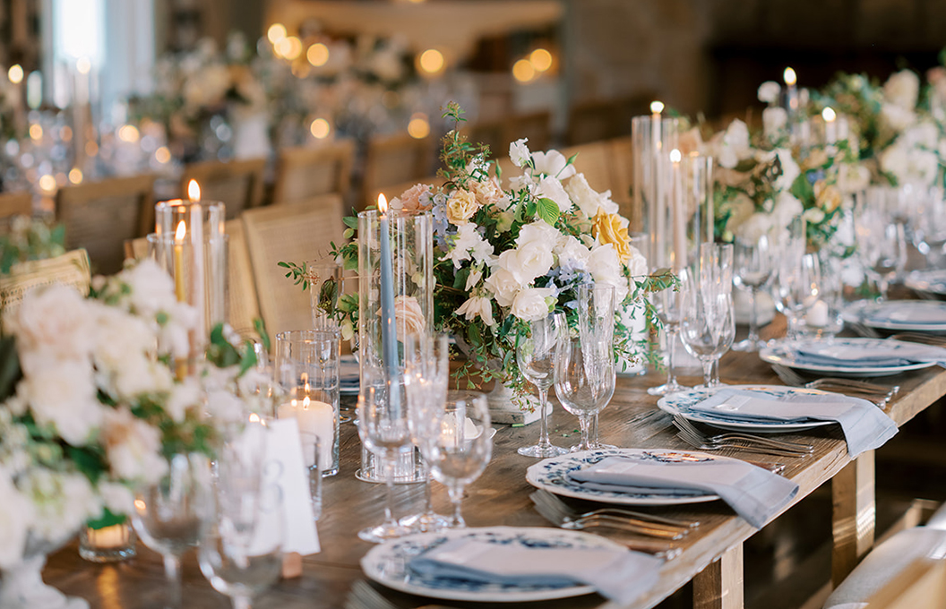 a table with white flowers and candles