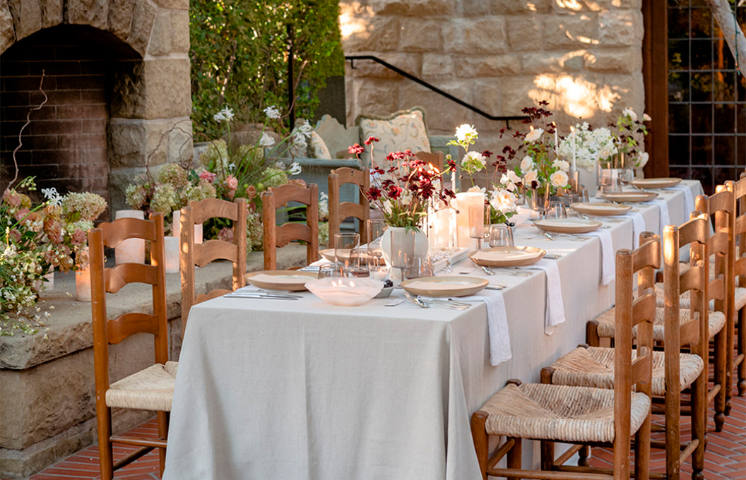 a dining table with white plates and flowers on it