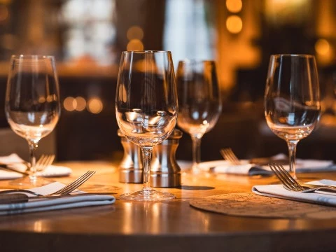 a table with wine glasses and silverware