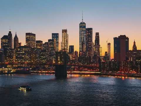 a city skyline with lights and a body of water