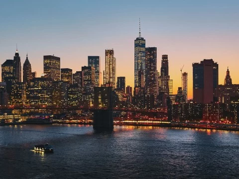 a city skyline with lights and a body of water