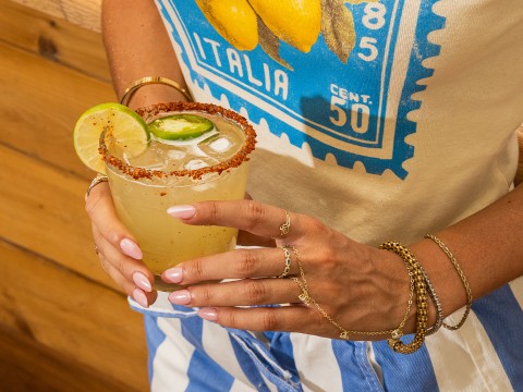 a woman holding a glass of liquid