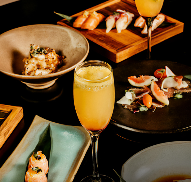 a table with plates of food and a glass of orange juice