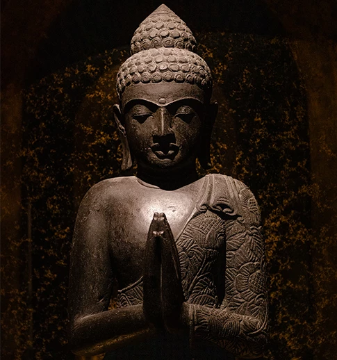 a statue of a person holding their hands together