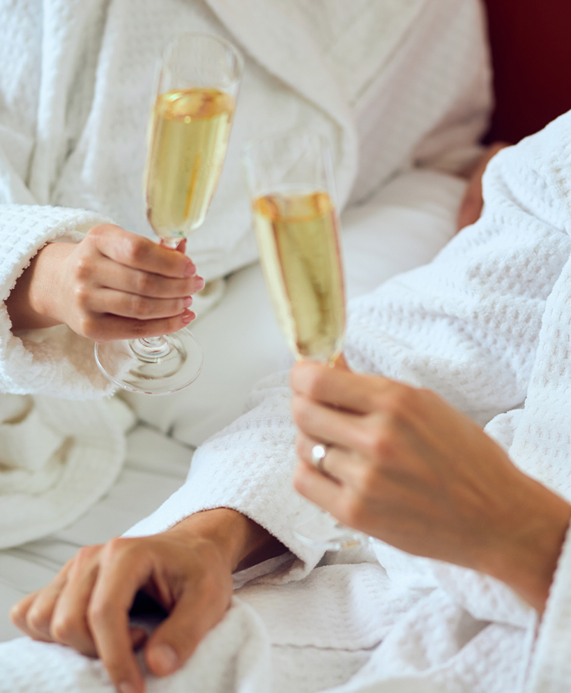 a pair of hands holding champagne glasses