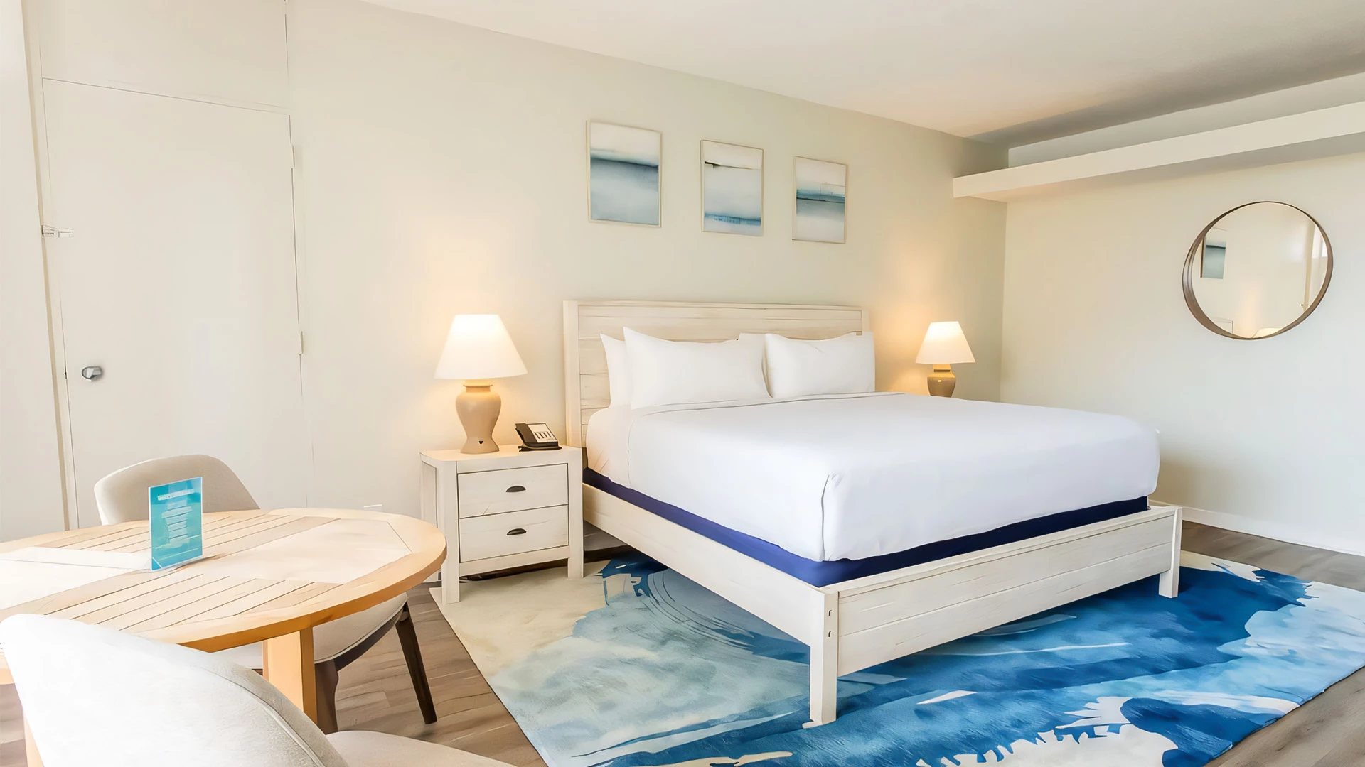 A hotel room with a bed, nightstand, and table.