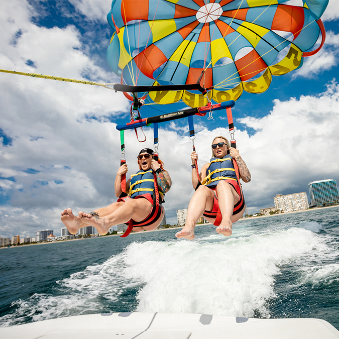 a couple of people parasailing on a boat