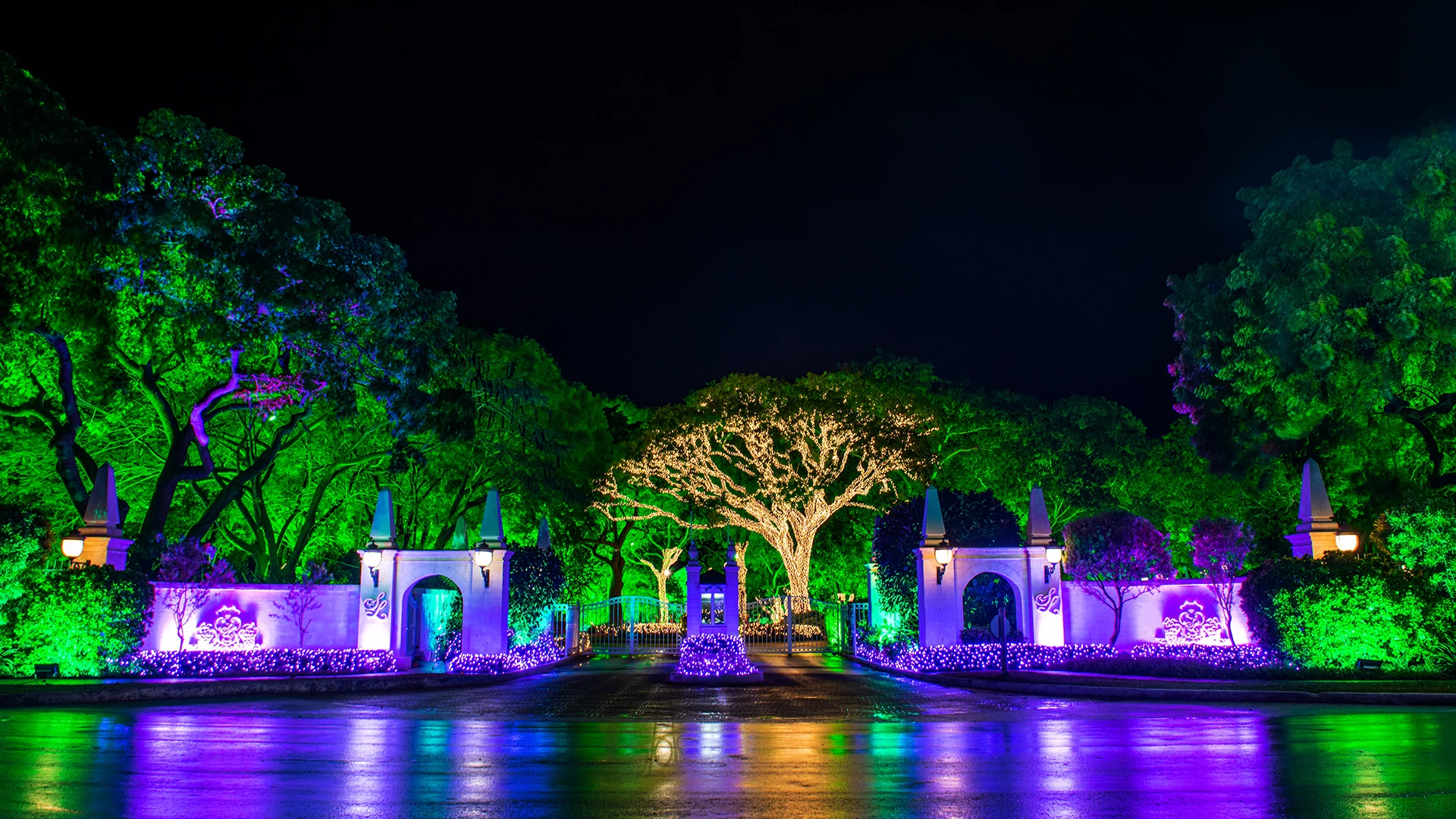 an entrance of a resort with trees and buildings around it