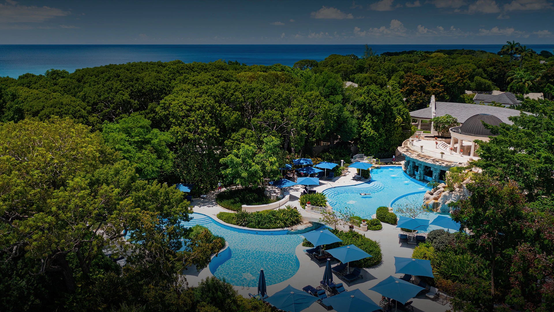 a pool surrounded by trees and a building with a pool