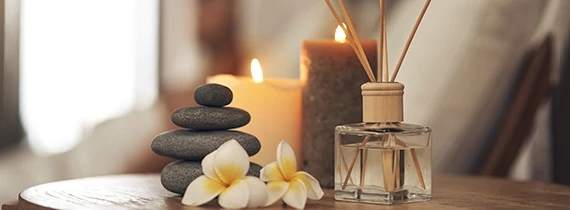 candles rocks and flowers next to each other in a spa