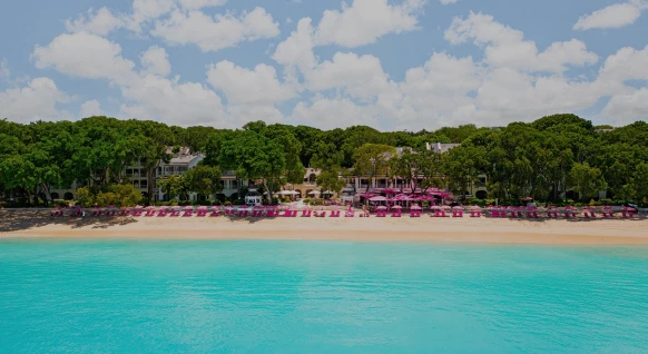 a beach with pink chairs and umbrellas